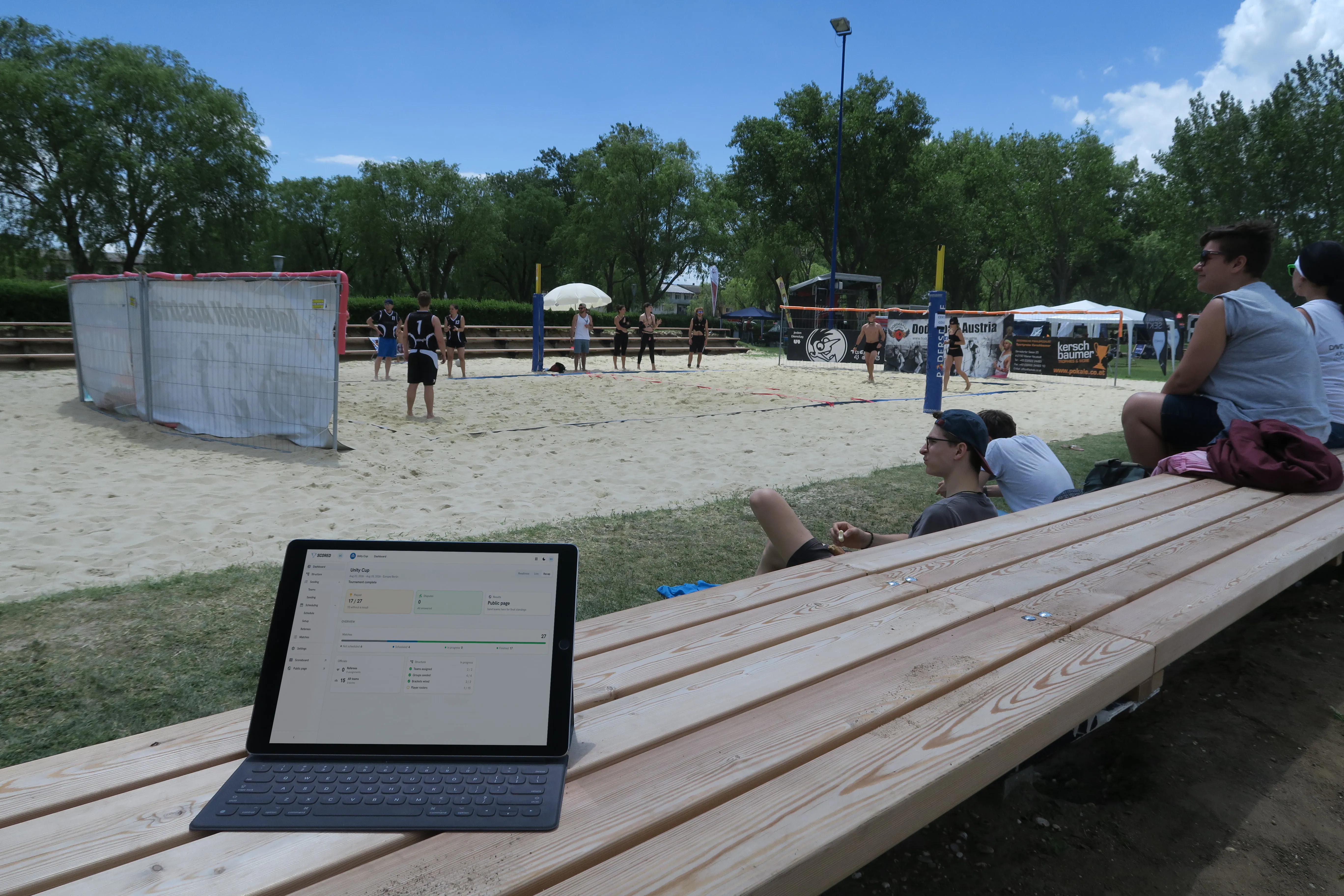 An organizer checking the tournament dashboard on an iPad, courtside