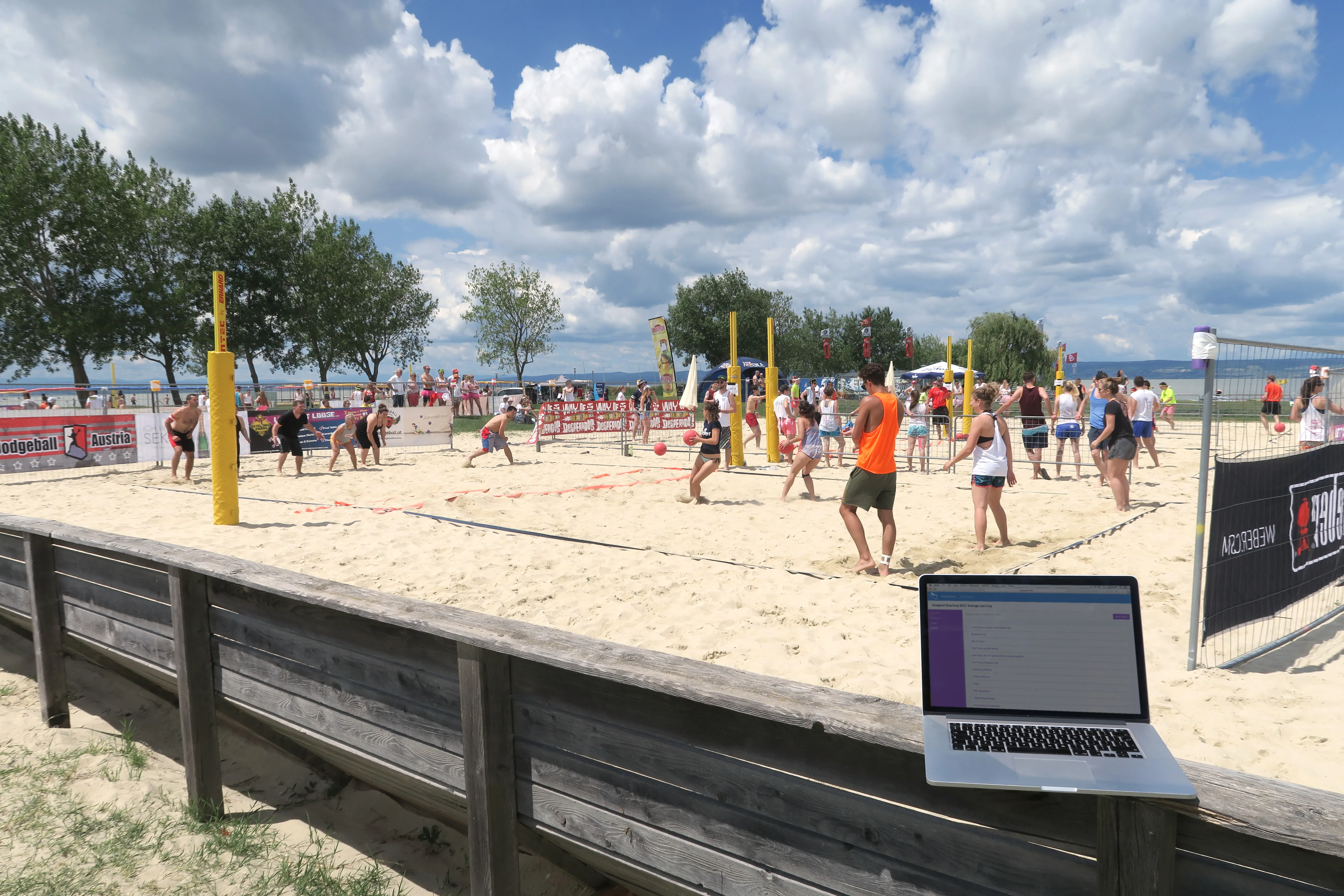 Scored running on a laptop beside a live outdoor tournament